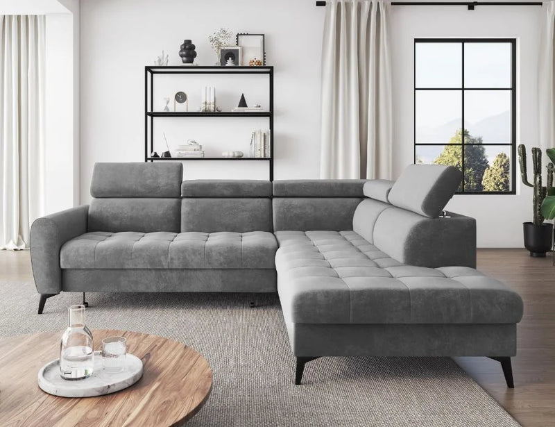 BJORN L corner sofa bed in gray velour with adjustable headrests and quilted seats in a modern living room.